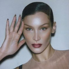 a woman with her hand up to her face