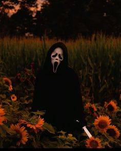 a person wearing a mask and holding a knife in a field of sunflowers