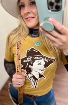 Texas True Threads Mustard Western Vibes Tee | Gussieduponline Saddle up for some serious style with our Mustard Western Vibes Tee! Featuring a vintage western graphic and playful wordplay, this cowgirl-approved tee is perfect for adding a bit of quirky charm to your wardrobe. From small businesses online boutique, this tee is a must-have for any western gal. Ride into style with our Mustard Western Vibes Tee! This quirky, vintage-inspired short sleeve tee features a vibrant mustard color and a Graphic Tees Western, Women's Western Wear, Vintage Western Style, Western Vibes, Western Boutique, Western Graphic Tees, Western Wear For Women, Graphic Tees Vintage, White Boots