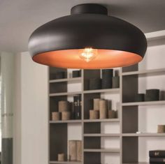 a light that is hanging from the ceiling in a room with many bookshelves