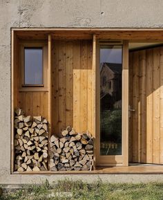 a stack of firewood sitting in front of a wooden door