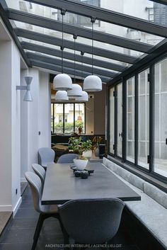 a dining room table and chairs under a glass roof