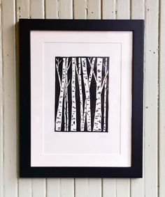 a black and white framed art print with trees in the woods on it's wall