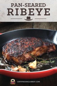 the steak is being cooked in a skillet with garlic and herbs on it, along with text overlay that reads pan - seasoned ribeye