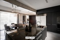 a modern kitchen with black cabinets and stainless steel counter tops is pictured in this image