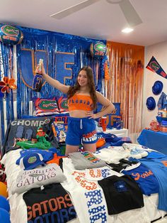 a woman standing on top of a bed in a room filled with balloons and t - shirts