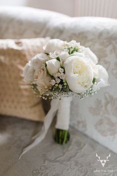 a bouquet of white flowers on a couch