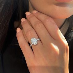 a close up of a person wearing a ring with a diamond on it's finger