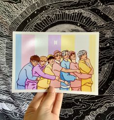 someone holding up a card with an image of people hugging