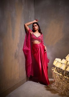 Our rose cape set presents a blend of feminine grace with its flowing skirt and hand-embellished blouse. The billowing cape adds an opulent touch to the ensemble, adorned with delicate embellishments. Elegant Draped Pink Lehenga, Elegant Pink Draped Sets, Elegant Draped Pink Sets, Pink Draped Lehenga For Party, Festive Pink Dress With Cape Sleeves, Chic Pink Festive Set, Pink Georgette Dress With Cape Sleeves, Festive Cape Dress With Draped Sleeves, Chic Pink Festive Sets