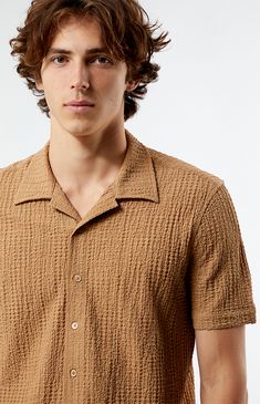 PacSun introduces the Pointelle Textured Woven Camp Shirt, showcasing a collared neckline and button-up front for a classic look. Crafted from crinkled fabrication, this shirt features short sleeves, offering both comfort and style in one piece.


	Collared neckline
	Short sleeves
	Button closures
	Standard fit
	Crinkle fabric
	97% polyester, 3% spandex
	Machine washable
	Model is wearing size medium
	Model Measurements: 6’1”  Height, 30” Waist, 35” Hips Summer Shirt With Johnny Collar And Buttons, Brown Collared Top With Placket, Summer Top With Collar And Placket, Collared Shirt With Placket For Summer, Summer Button-up Top With Placket, Summer Collared Shirt With Placket, Summer Short Sleeve Shirt With Collar And Placket, Summer Short Sleeve Collared Shirt With Buttons, Spring Camp Shirt With Collared Neckline And Button Closure