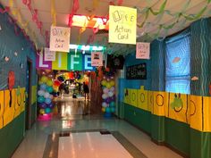 a hallway decorated with balloons, streamers and signs for an arts and crafts class