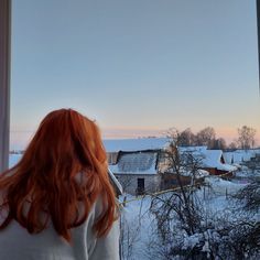 a woman looking out the window at snow covered houses