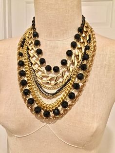 Made in USA. Designed and made by Mirela Skikic Voss - Louisville, KY Elegant, classy, and trendy piece of jewelry for every occasion. Made of several different gold and black color chains, and of glass black beads. It opens/closes behind the neck with a lobster clasp. Excellent gift idea. Black Chunky Chain Necklace, Black Multi-strand Costume Jewelry Necklace, Black Chain Necklace Costume Jewelry, Black Beaded Chain Costume Jewelry Necklace, Black Necklace With Gold Chain Link Detail, Black Necklace With Gold Chain Link, Party Chain Necklace With Black And Gold Chain, Party Black Chain Necklace With Gold Chain, Black Costume Jewelry Necklace With Adjustable Chain