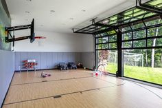 an indoor basketball court with lots of windows and equipment on the floor in front of it