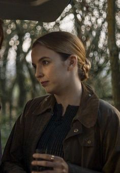 two women standing next to each other in the woods