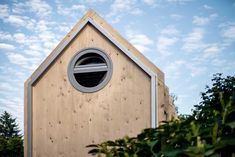 a small wooden building with a round window