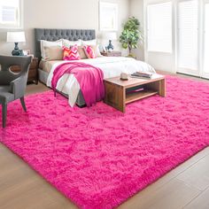 a bright pink carpet in a bedroom with a bed, chair and window sill