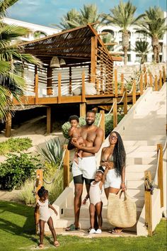 a man and two women are standing on the steps with their baby in front of them