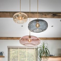 three lights hanging from the ceiling in a kitchen