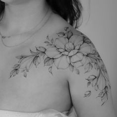 black and white photograph of a woman's chest with flowers tattooed on her arm