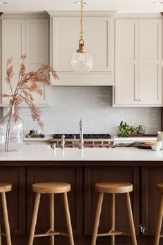 three stools sit in front of a kitchen island