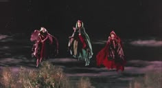 three women dressed in red and green flying through the night sky