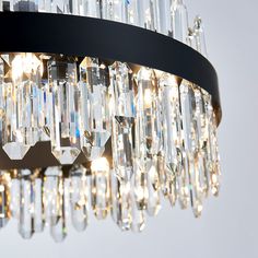 a chandelier with many crystal drops hanging from it's black metal frame