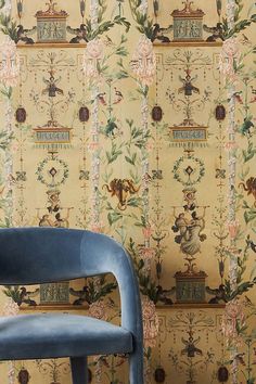 a blue chair sitting in front of a wallpaper