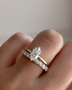 a woman's hand with two engagement rings on it