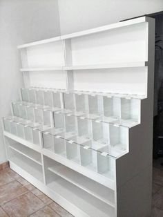 a white book shelf filled with lots of clear plastic bins on top of it