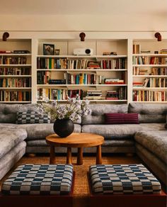 a living room filled with lots of furniture and bookshelves covered in shelves full of books