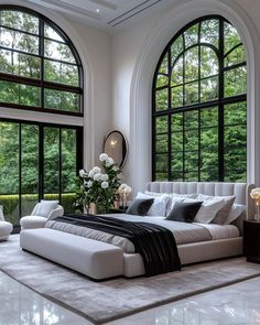 an elegant bedroom with large windows and white furniture