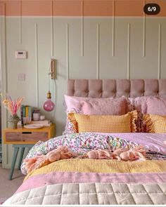 a bed with pink and yellow comforters in a bedroom