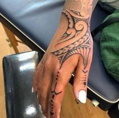 a woman's hand with a tattoo on it sitting next to a blue chair