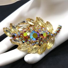 *Description: This is a beautiful yellow rhinestone and topaz aurora borealis rhinestone leaf brooch with a gold plated backing from the 1960s. This would be a great addition to your vintage jewelry collection or make a great vintage gift! *Approximate Measurements: Length - 2 3/4 Inches, Width - 1 3/4 Inch *Condition: Great vintage condition. Will see signs of wear under magnification. See photos for details. *Hallmark: Unsigned *Item # 4938 Please look at the photos carefully as they are a par Antique Costume Jewelry, Vintage Rhinestone Jewelry, Leaf Brooch, Jewelry Boards, Gorgeous Bracelet, Rhinestone Jewelry, Vintage Rhinestone, Vintage Costume Jewelry, 1960s Vintage