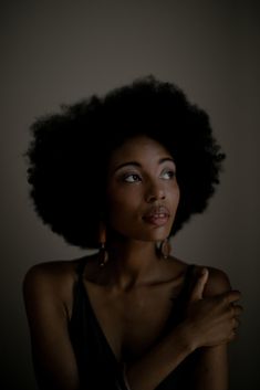 a woman with an afro is posing for the camera