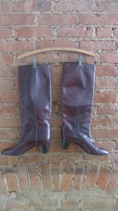 "1970s burgundy wine leather boots almond shaped toe conical wooden heel knee high black leather piping pull on style perfect for tucking your vintage jeans! made in Italy ○ Circa: 1970s ○ Label: Frank More, Italy ○ Material: Leather ○ Color: Red Wine ○ Condition: Excellent! Shoes have been worn. Modern Size Estimate: US 8 * EU 38.5 * UK 5.5 * AU 6.5 (Shoe Marked a Vintage Size 8.5) ○ Insole: 9.875\" ○ Ball Width: 3\" ○ Shaft Height: 16\" ○ Shaft Width: 13.5\" ○ Heel Height: 2\" ❉ this is a vint Retro Fall Heeled Boots, Retro Knee-high Boots For Fall, Retro Heeled Boots For Formal Fall Occasions, Retro Heeled Boots For Fall Formal Events, Retro Knee-high Fall Boots, Vintage Wide Calf Knee-high Boots For Fall, Retro Wide Calf Boots For Fall, Retro Knee-high Winter Boots, Retro Fitted Boots For Formal Occasions