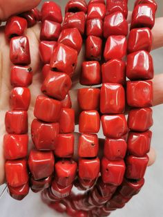 the red beads are being held by someone's hand