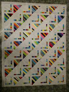 a quilt made with strips of different colors