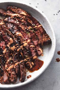 steak with sauce in a white bowl on a table