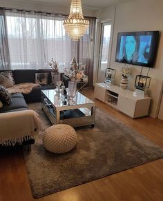 a living room filled with furniture and a flat screen tv on top of a wooden floor