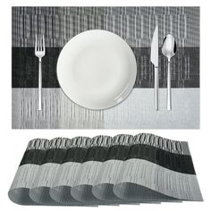 a table setting with place mats, forks and spoons on the plate next to each other