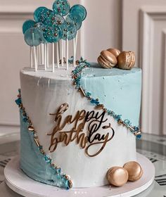 a blue and white birthday cake with gold decorations