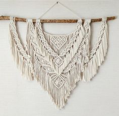 a white wall hanging with tassels on it