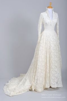 a white wedding dress with long sleeves and a high neckline, on a mannequin