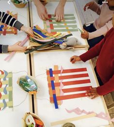 several children are making art with construction paper and scissors at a table that has tape on it