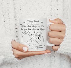 a woman is holding a coffee mug with writing on it and her hands are in the air