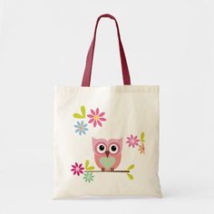 an owl sitting on a branch with flowers in it's beak tote bag