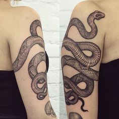 two women with tattoos on their arms, one has a snake and the other has a skull